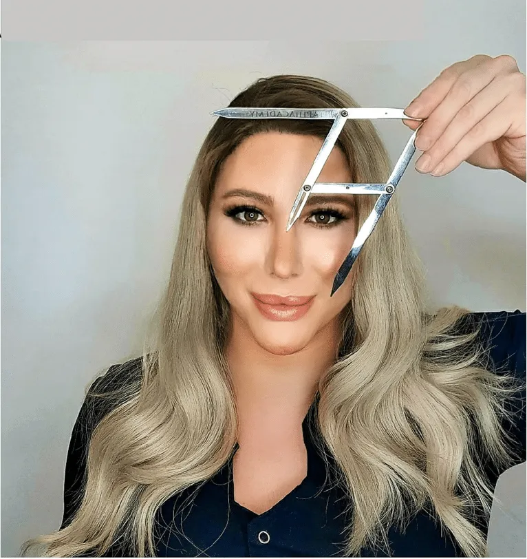 מאי לי, מייסדת הקליניקה, עם כלי מדידה לתכנון גבות